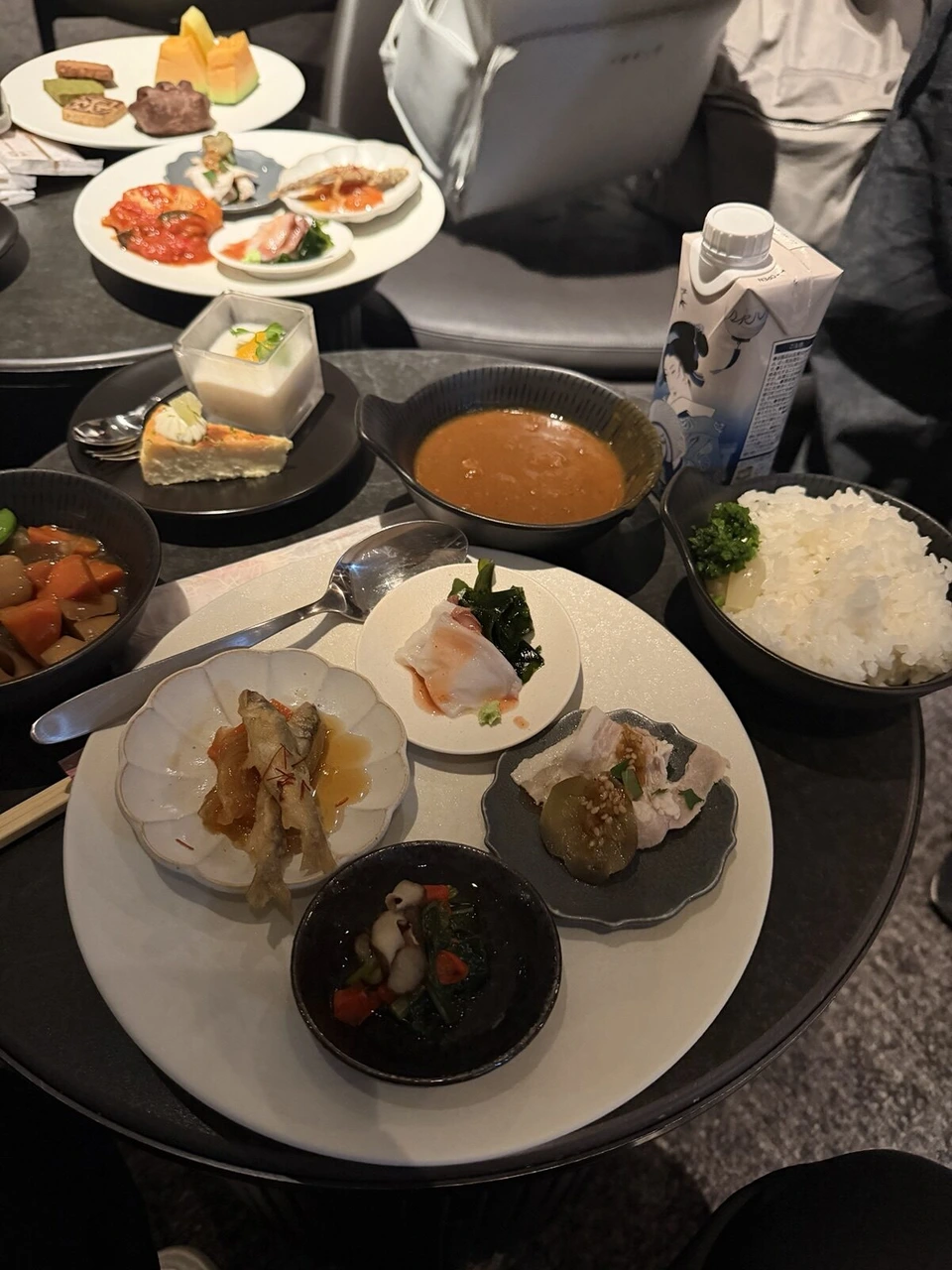 センチュリオン・ラウンジの料理。煮物やカレー、ご飯、小鉢をのせた皿