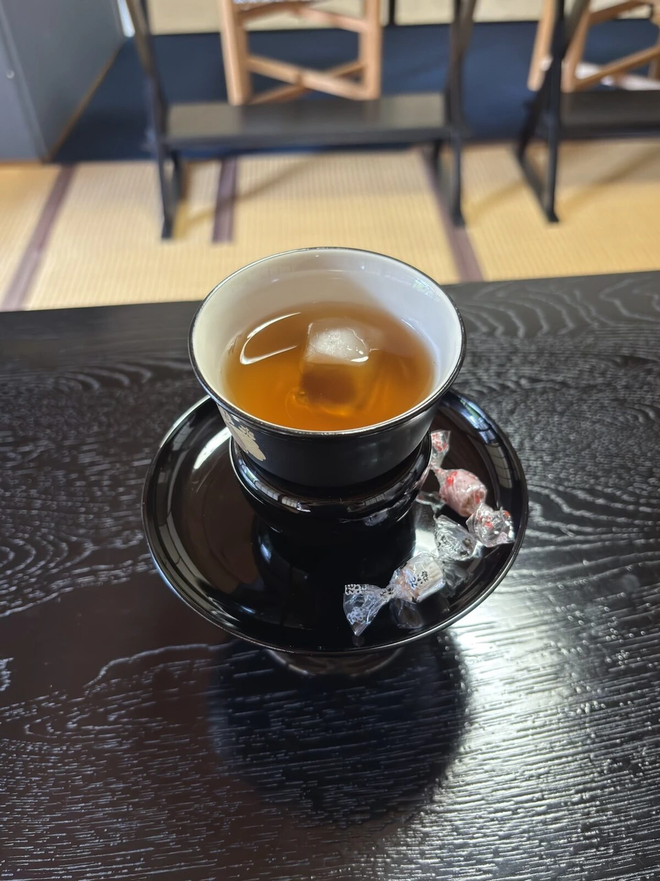 客殿ラウンジの畳の部屋と椅子、テーブルに置かれた冷たいお茶