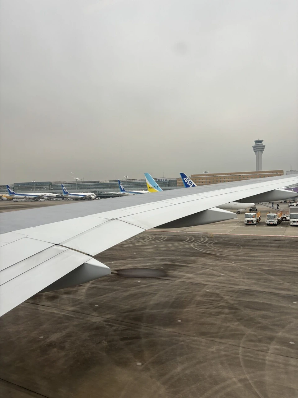 羽田空港に着いたANA機の窓から見た主翼と管制塔