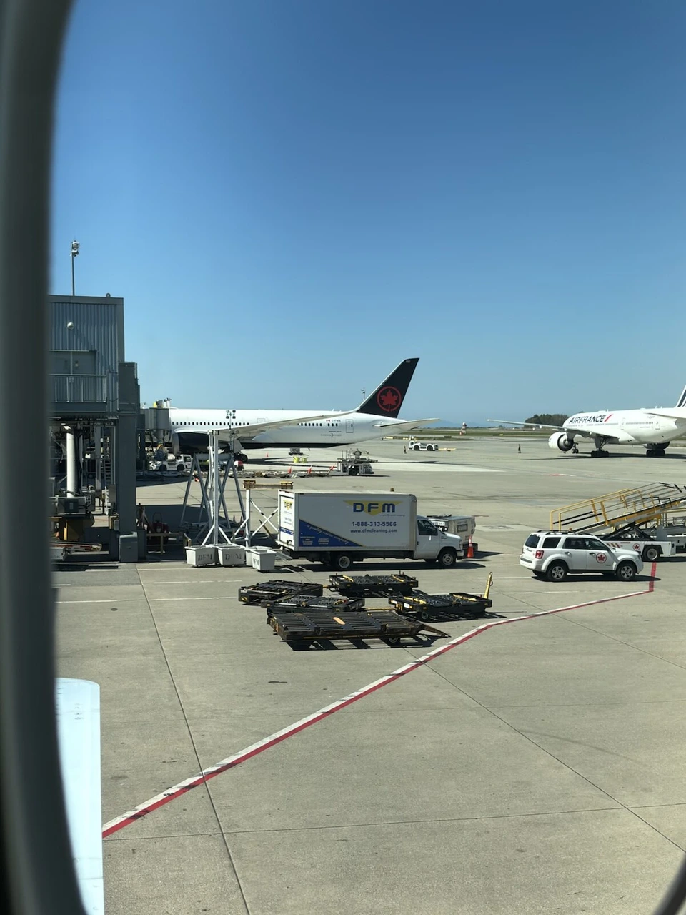 AC23 Signature Classの座席4Kの窓から見たバンクーバー空港の駐機場とエア・カナダの尾翼