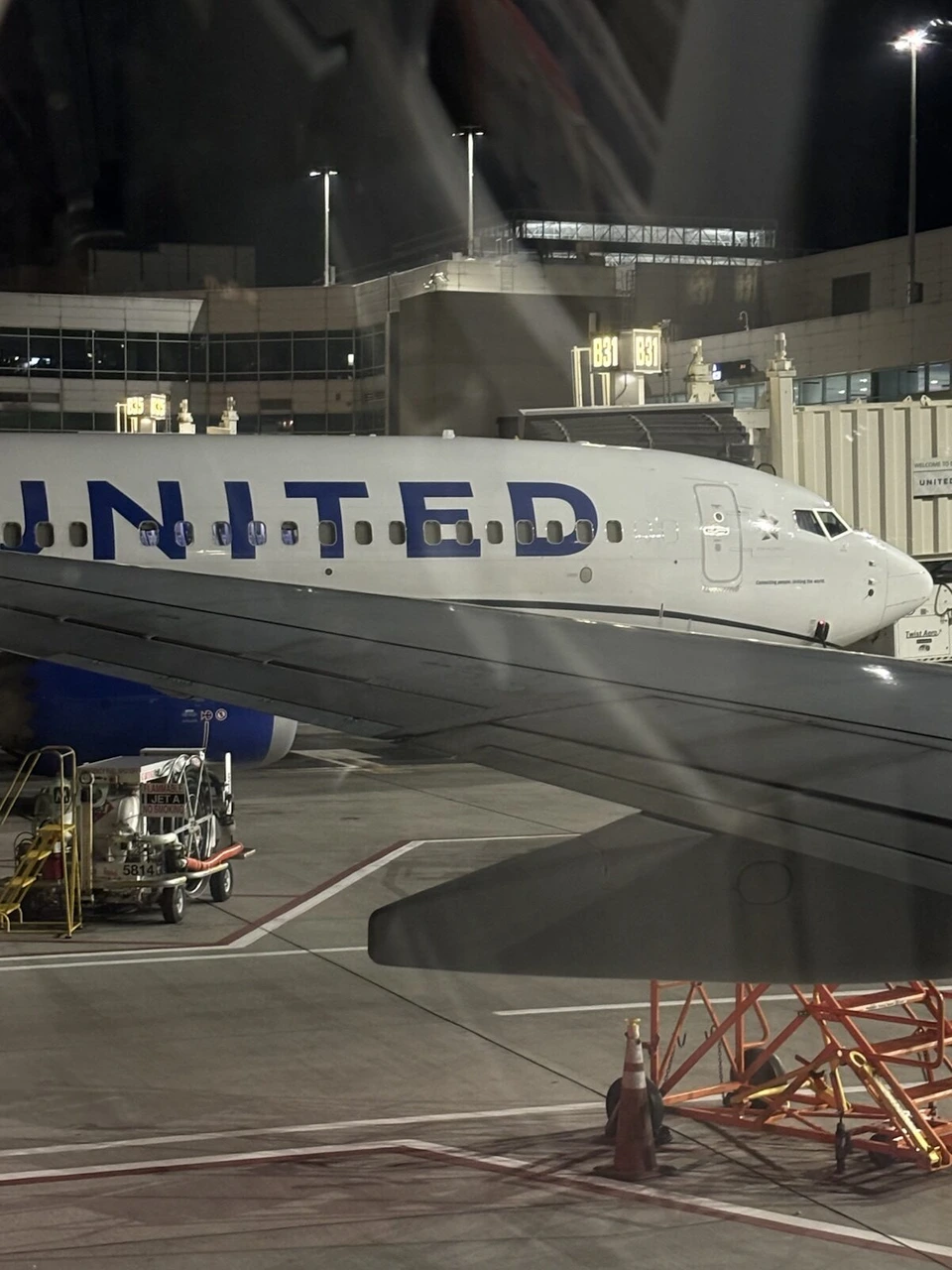 夜のデンバー空港。機内の窓から見たユナイテッド航空の機体と主翼