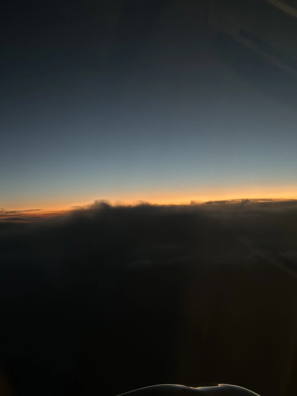 アラスカ航空E175の機窓から見た地平線の夕焼け