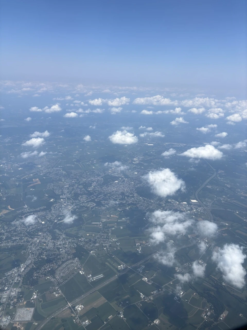 機窓から見下ろした雲と緑の多い地上