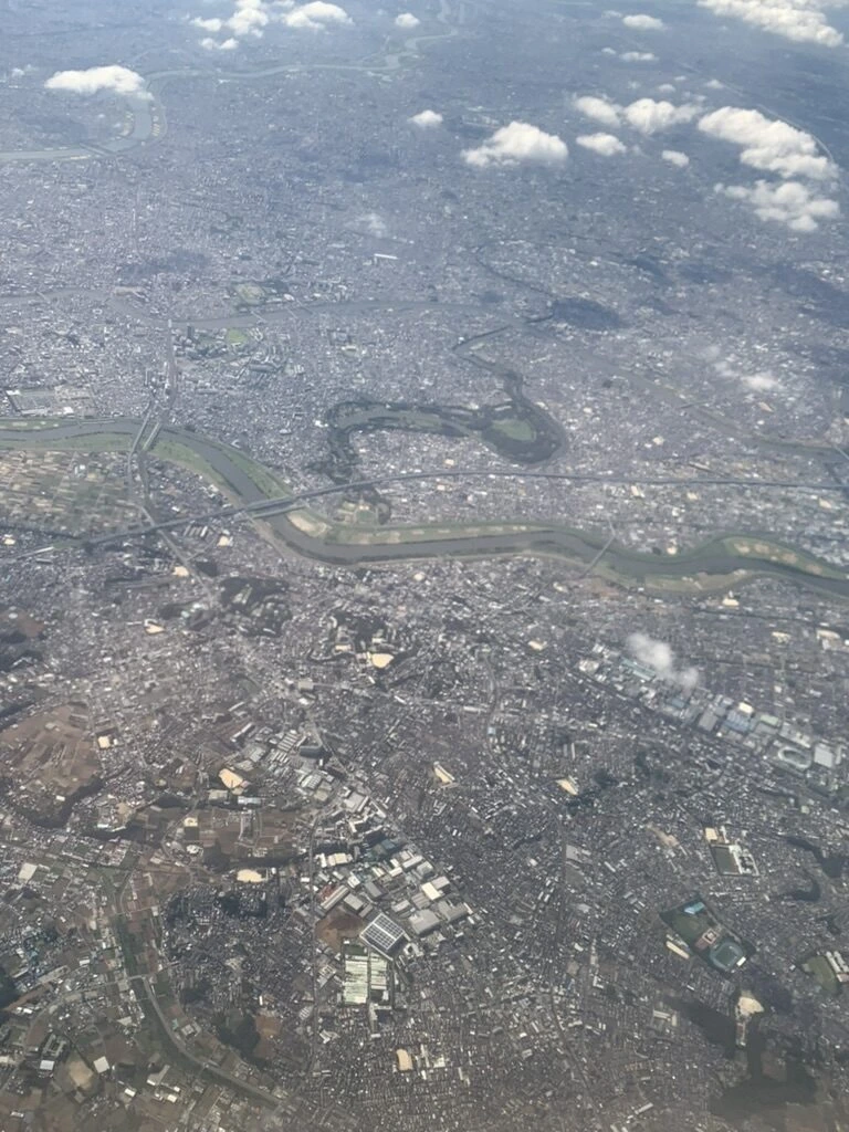 ANA721便の機窓から見た東京の市街地と蛇行する川