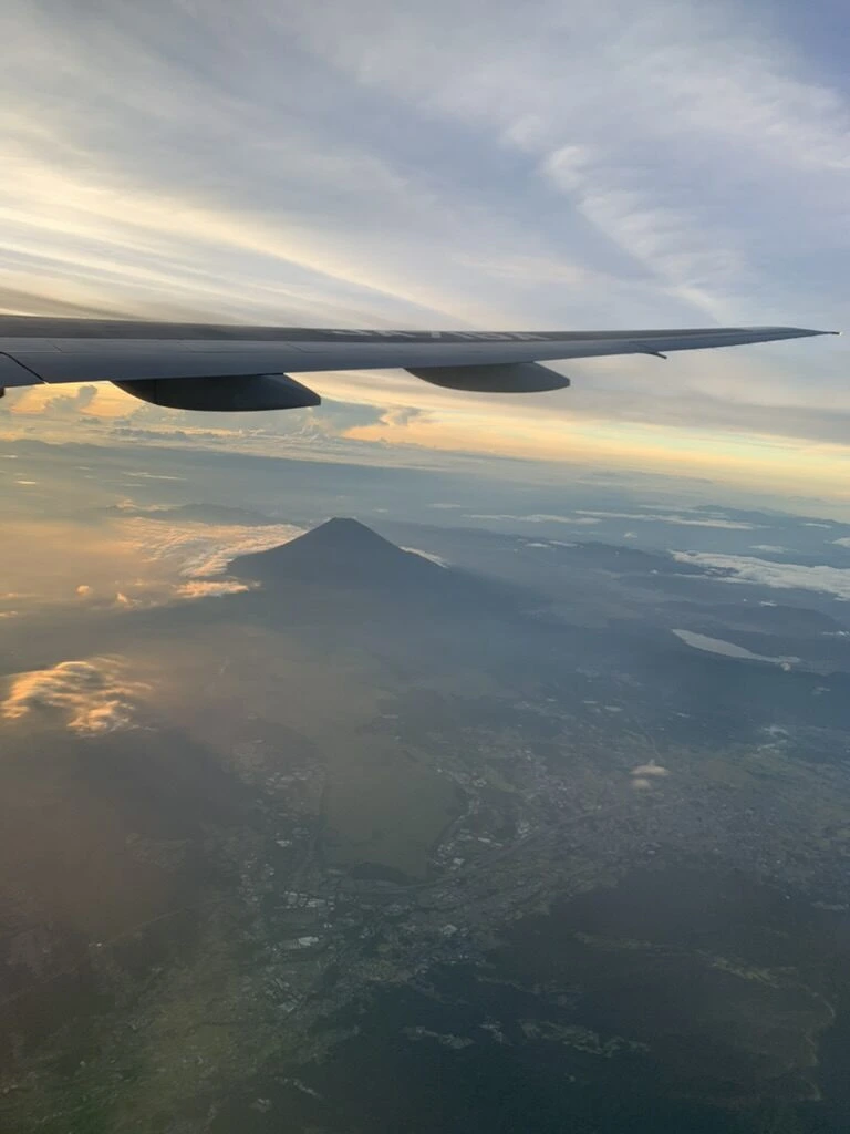 主翼の下に見える富士山と夕焼けの雲