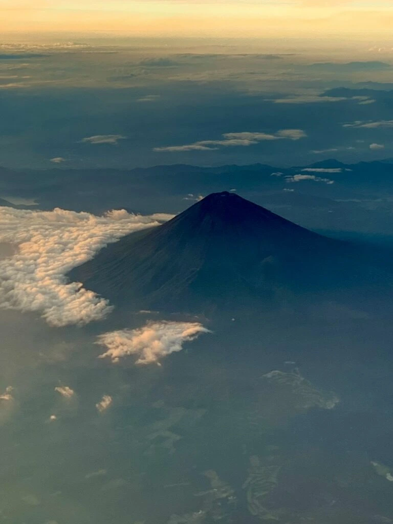 ANA1097便の機窓から見下ろした富士山の山頂と周りの白い雲