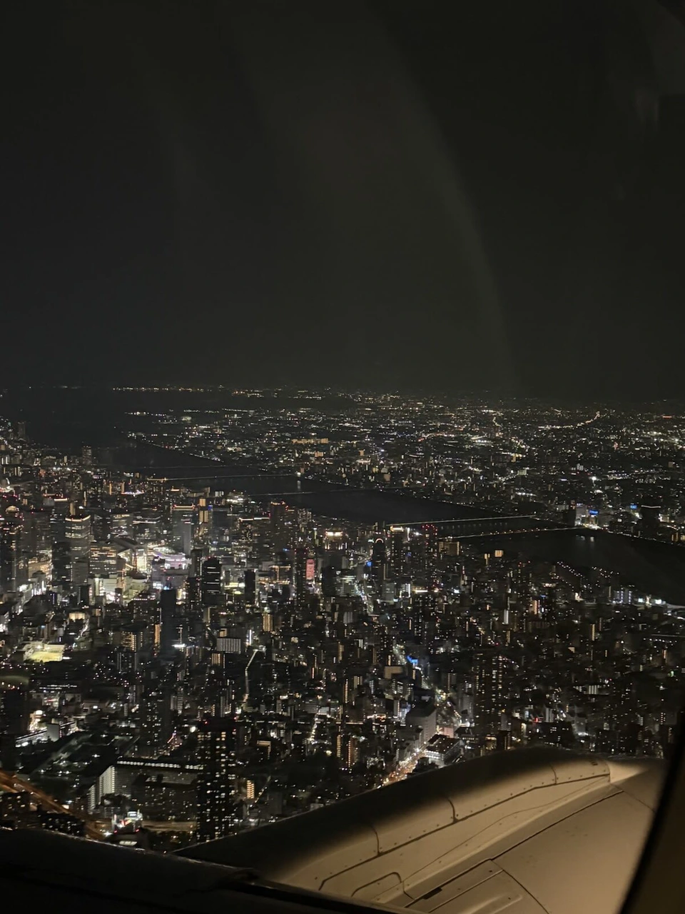 伊丹へ降りていく機内から見た大阪市街の夜景と主翼