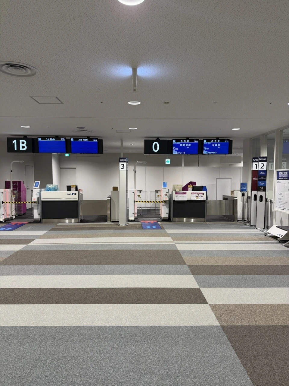 新千歳空港の搭乗口。並んだ搭乗口の番号表示と、Groupごとの案内の看板、人のいない待合