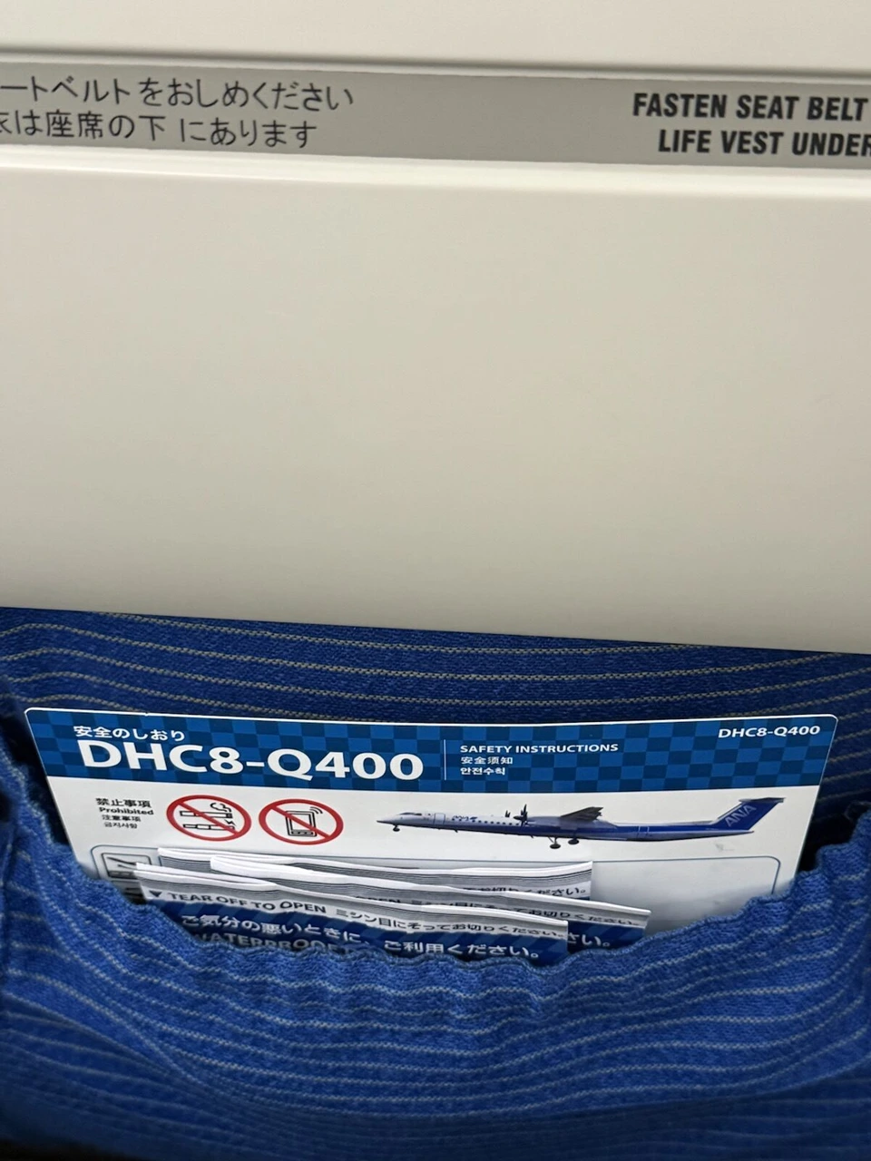 NH1834の座席ポケットに入ったANAの安全のしおり。DHC8-Q400の文字とプロペラ機の絵