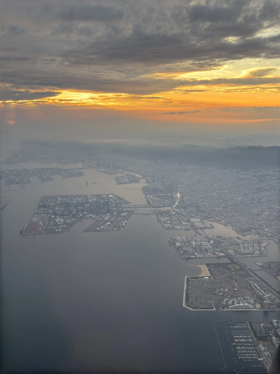 JL2439の機窓から見た夕焼けと大阪湾の埋め立て地