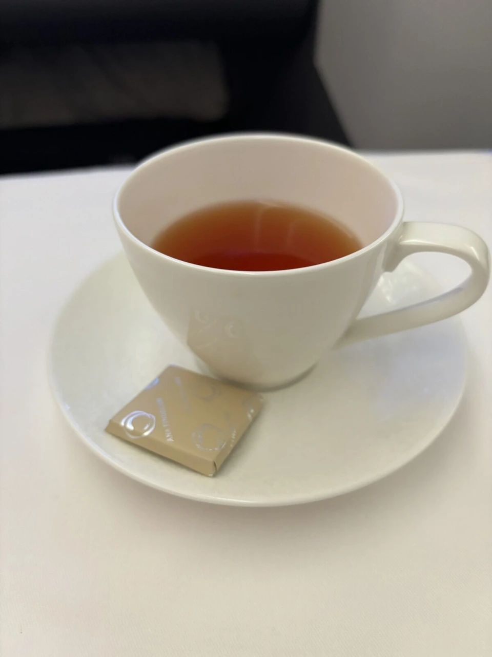 紅茶のカップと、ソーサーに添えられたチョコレート