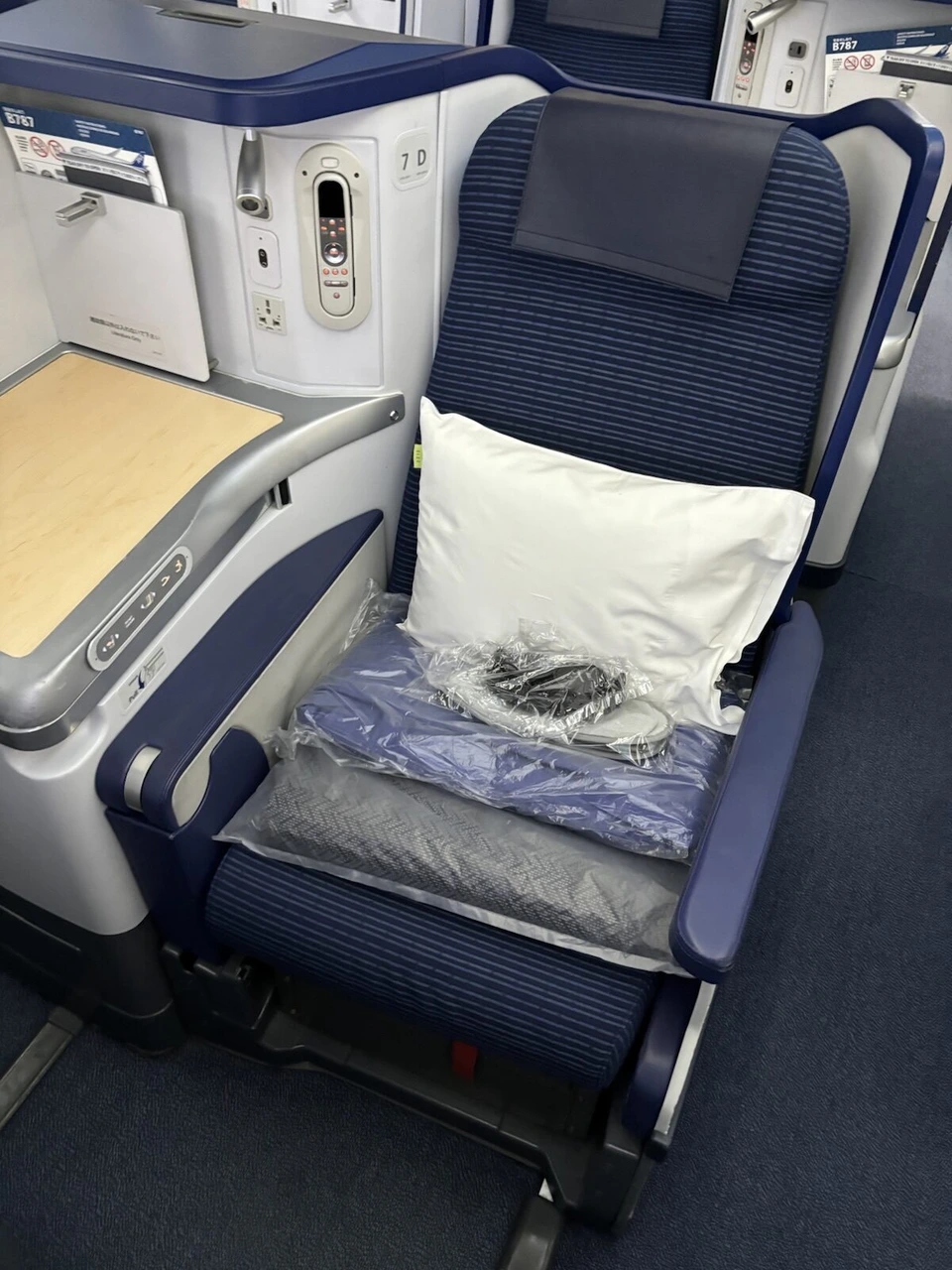 NH801のANA787-9ビジネスクラス（ANA BUSINESS STAGGERED）座席7D。枕と毛布、ヘッドホンが置かれている