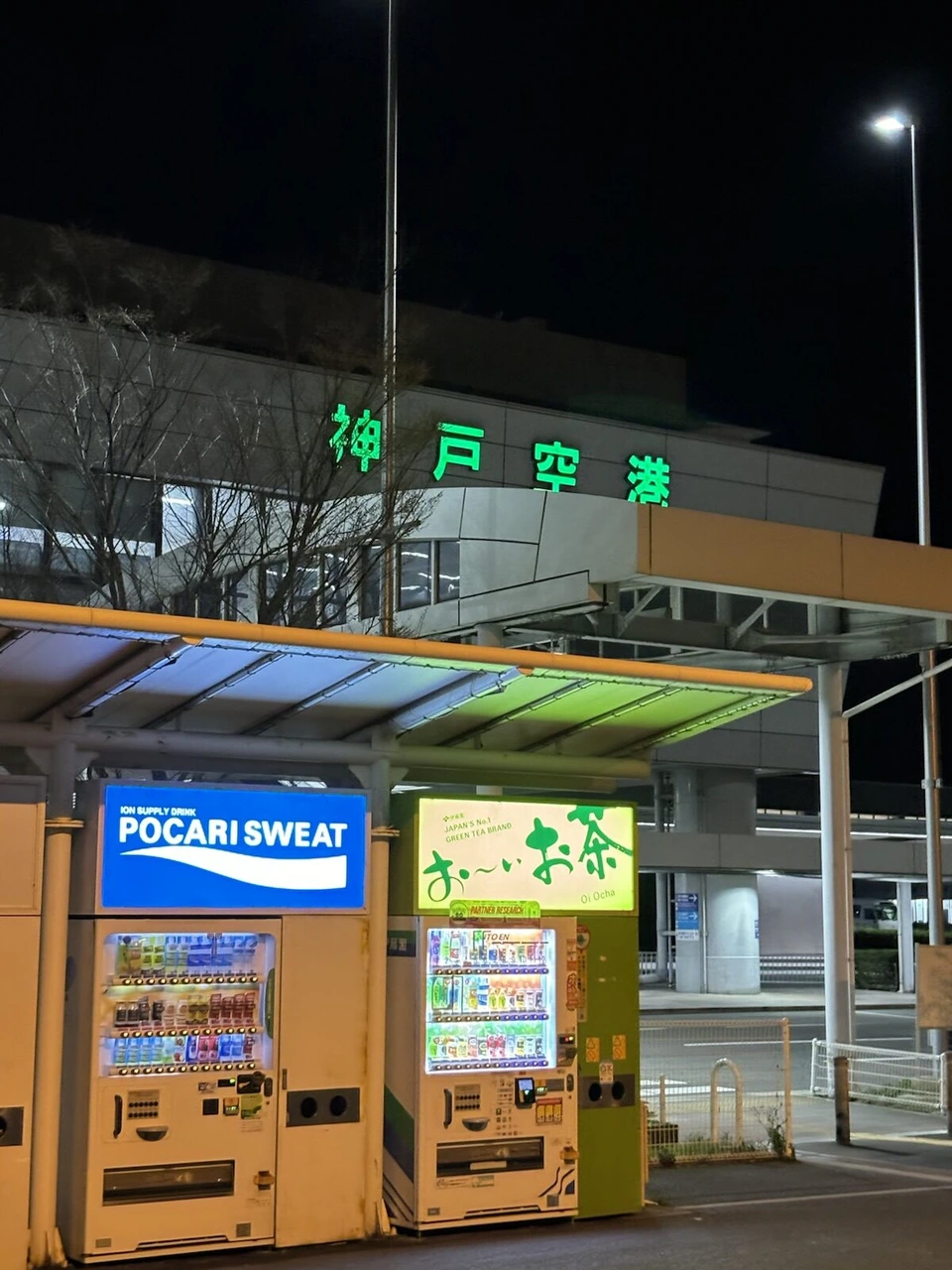 夜の神戸空港。「神戸空港」の緑の文字と自動販売機