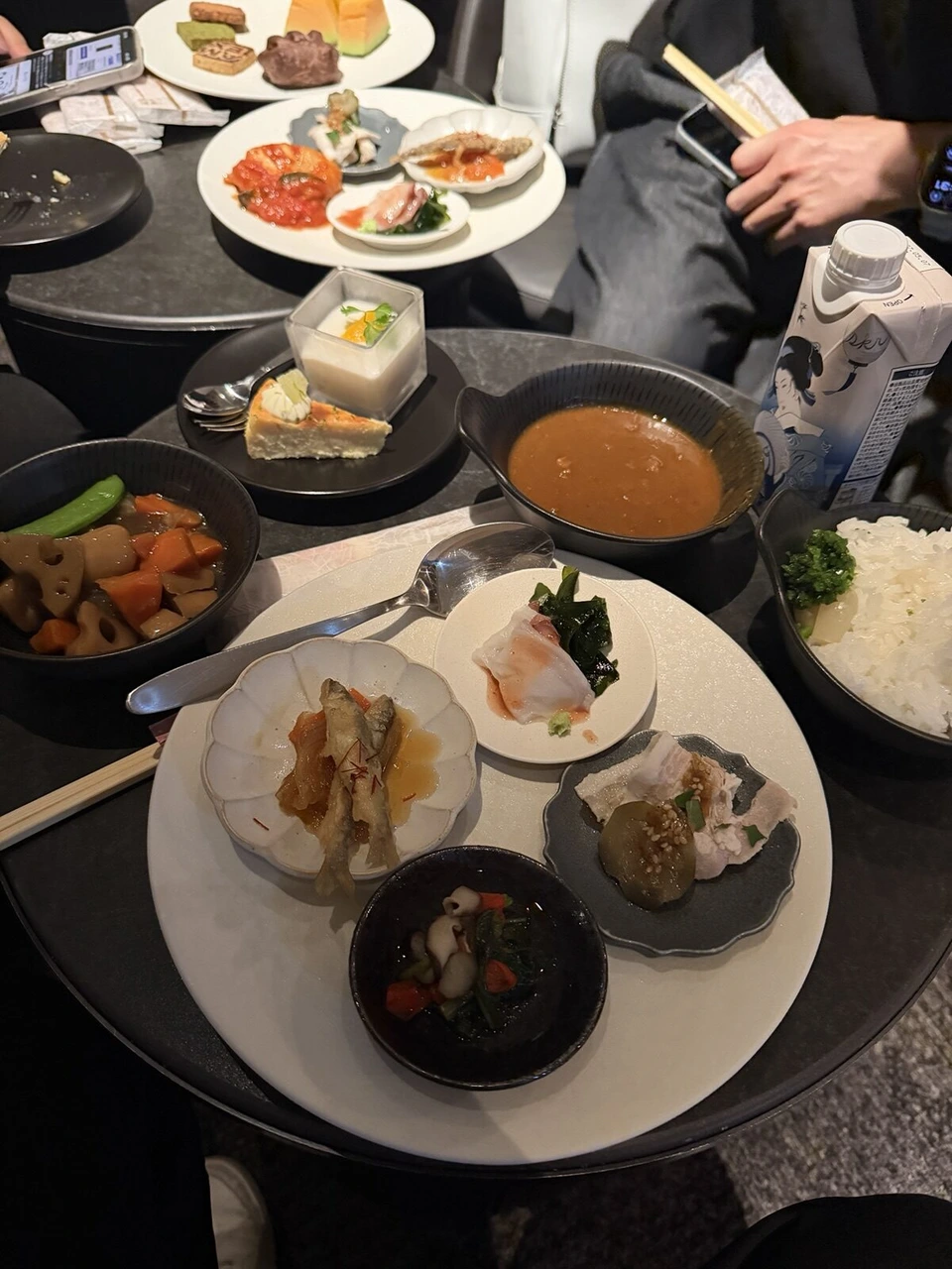 羽田空港第3ターミナルのセンチュリオン・ラウンジの料理。小鉢の和食、カレー、ご飯、サラダの皿