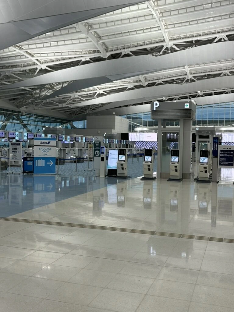 早朝の羽田空港第2ターミナル。自動手荷物預け機が並ぶ出発ロビー
