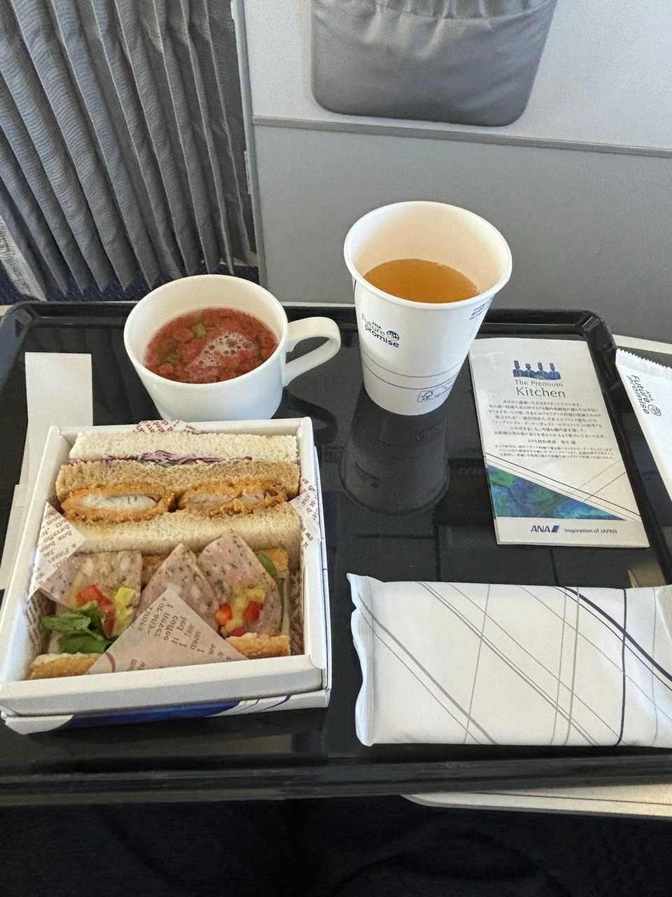 ANA国内線プレミアムクラスの朝食。箱に入ったサンドイッチとスープ、紙コップのお茶