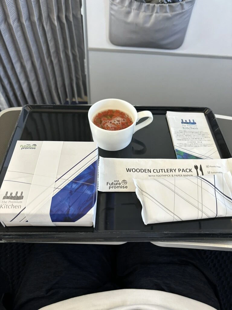 ANA NH411 羽田→神戸 プレミアムクラスの朝食。スープのカップとWOODEN CUTLERY PACK、メニューカード