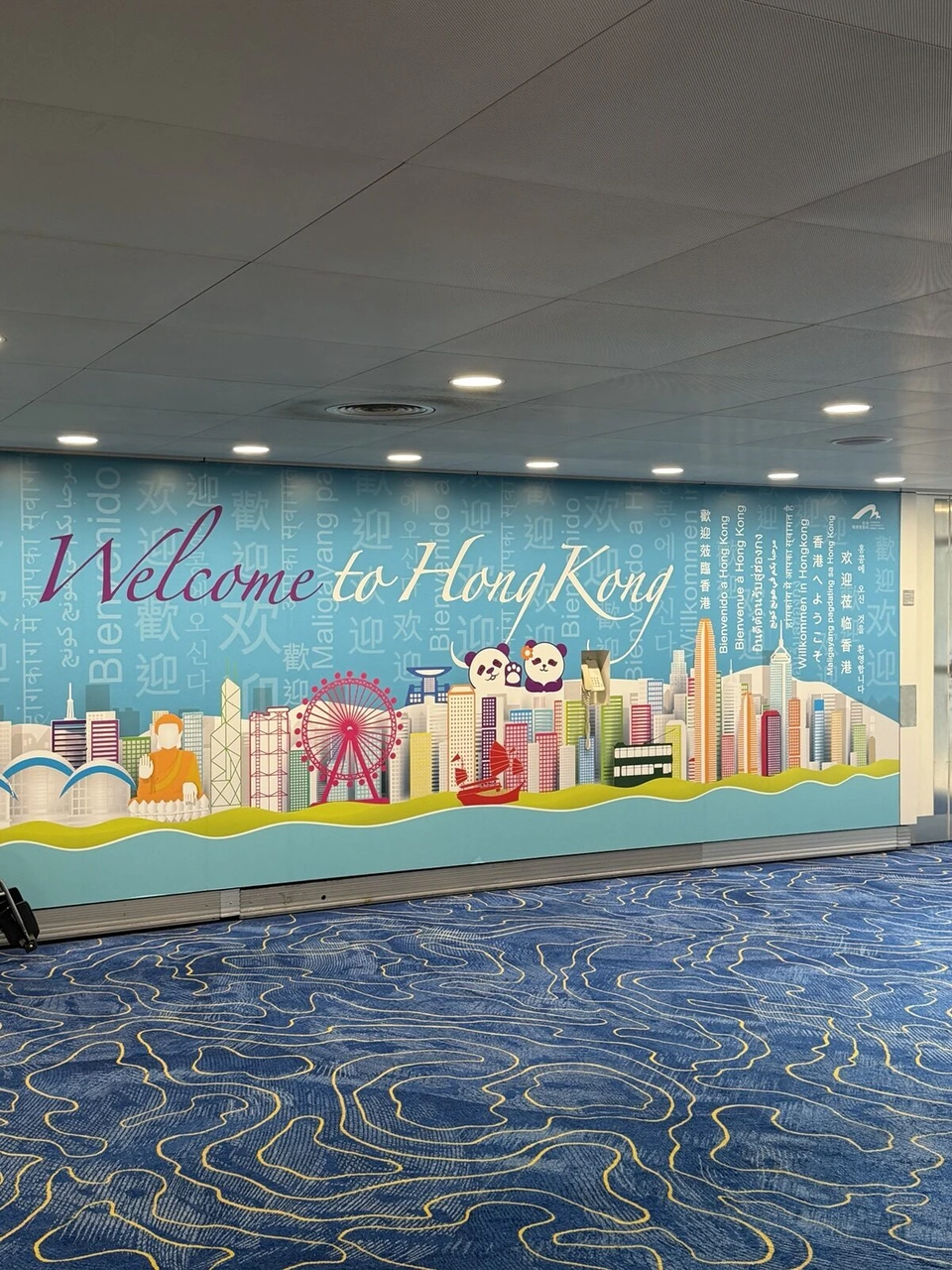 香港空港の通路のWelcome to Hong Kongの壁画。パンダや観覧車の絵