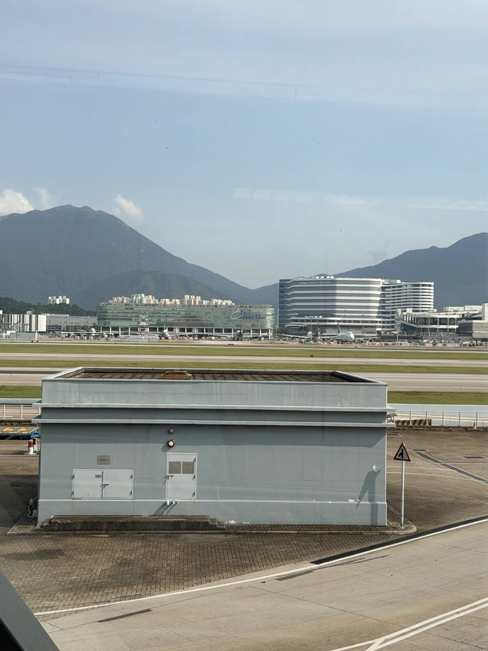 香港空港の窓から見たランタオ島の山と空港周辺のビル