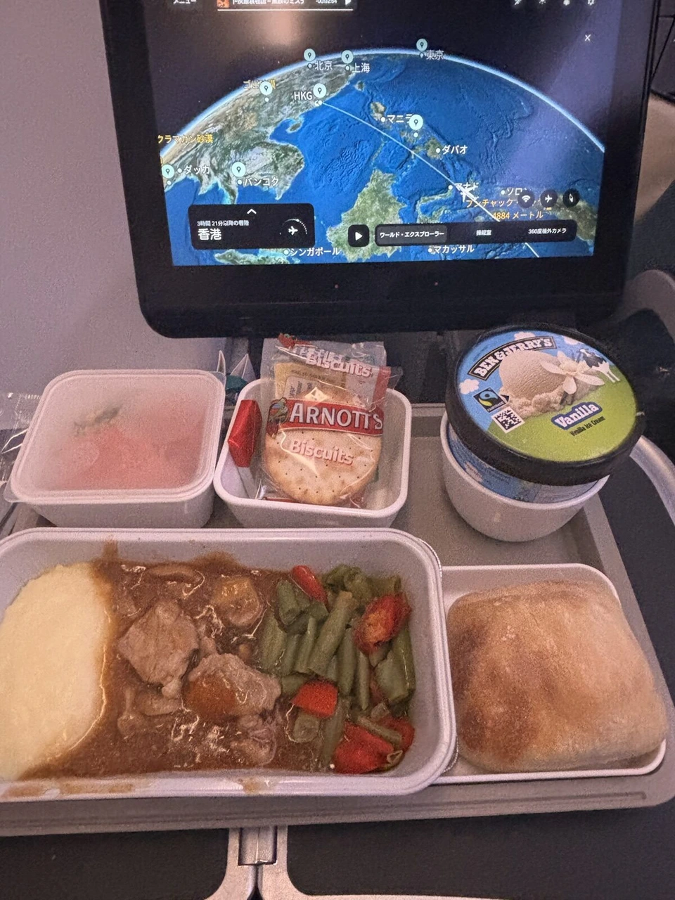 CX110の機内食。豚肉の煮込みといんげん、マッシュポテト、パン、アーノッツのビスケット、ベン&ジェリーズのバニラアイス