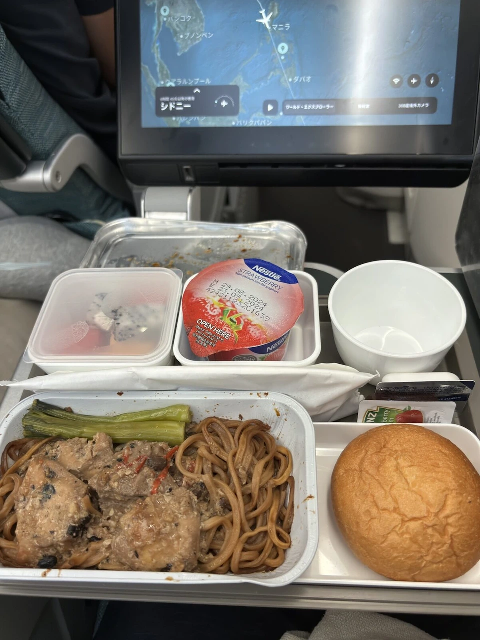CX139の1回目の機内食。焼きそばと肉の煮込み、パン、フルーツ、ネスレのいちごヨーグルト