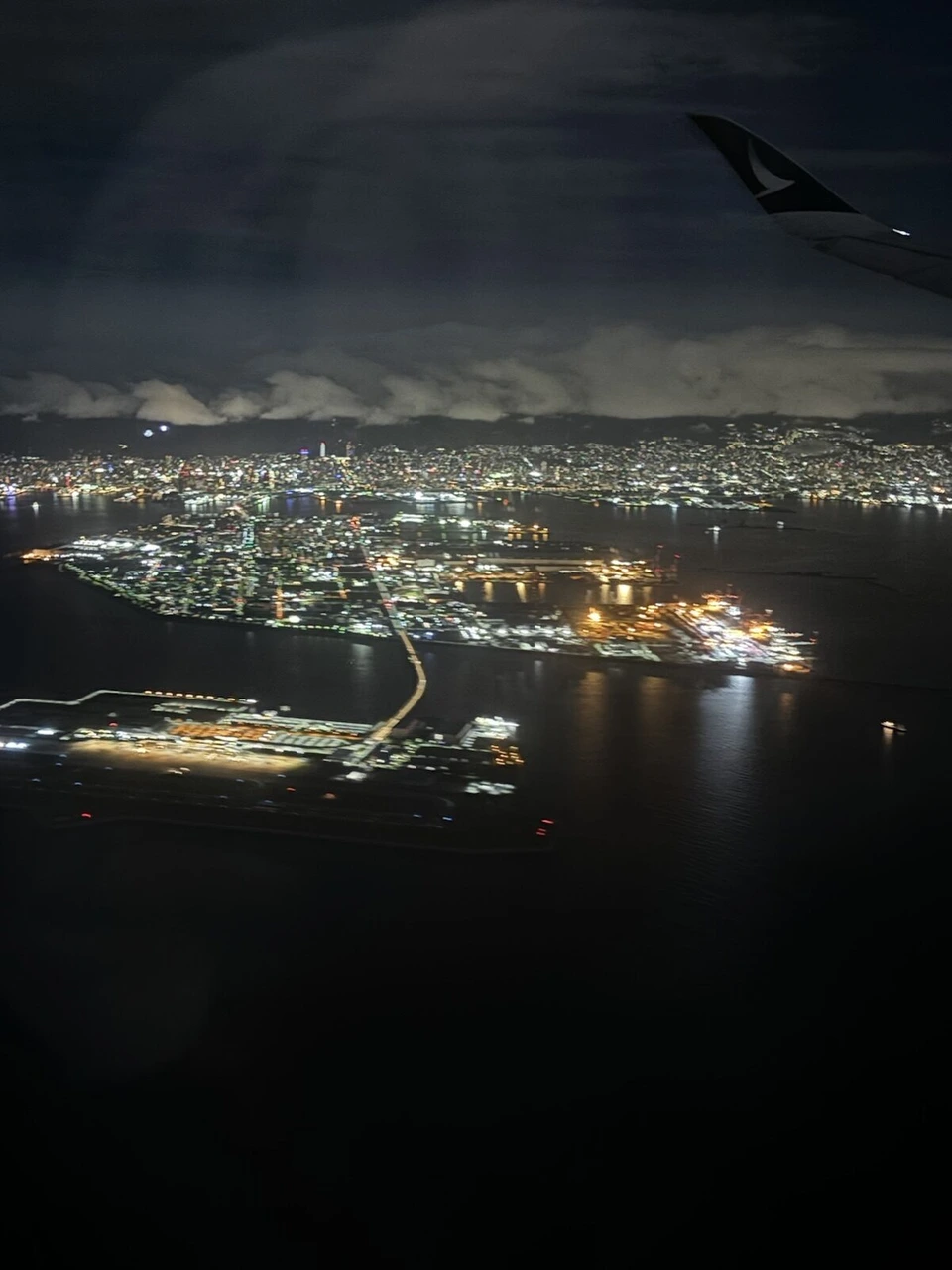 CX502の関空到着前の機窓。大阪湾岸の夜景と関空の連絡橋