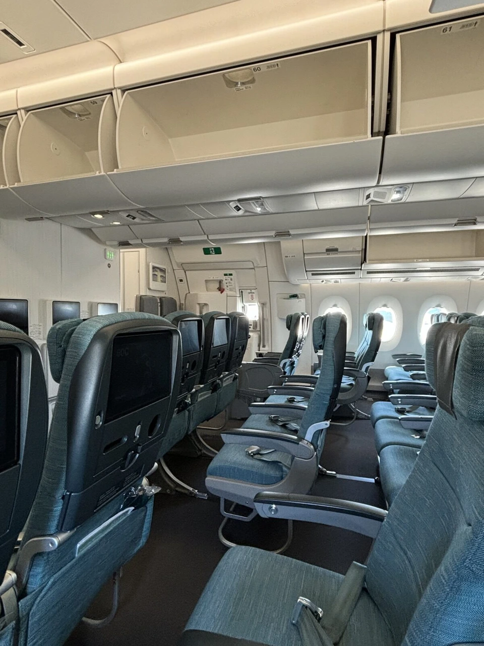 搭乗直後のキャセイパシフィックCX503(A350-900)のエコノミー客室。青緑の座席と座席背面の画面