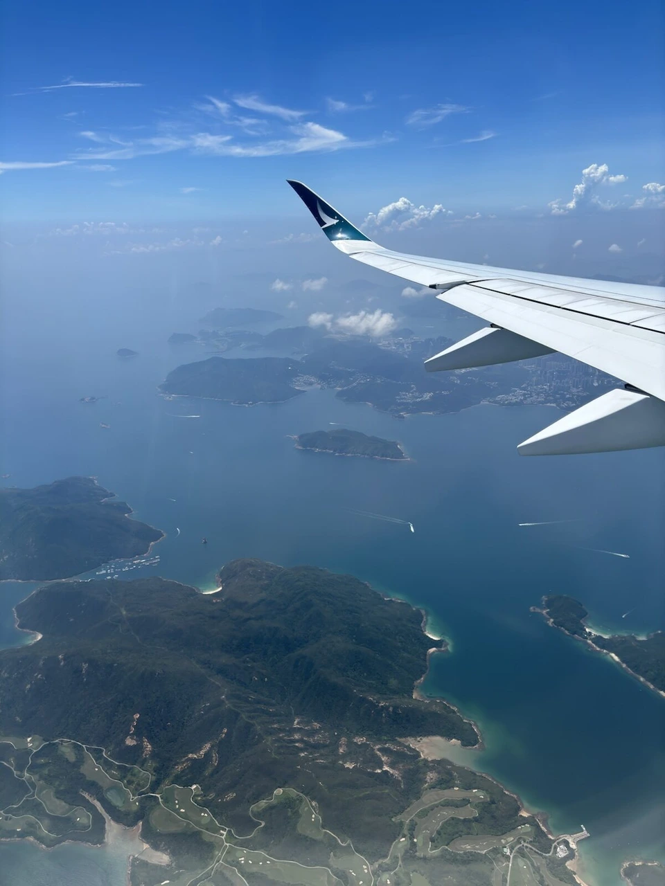キャセイパシフィックCX503(A350-900)の機窓。香港到着前、主翼の先に島と入り江が続く海