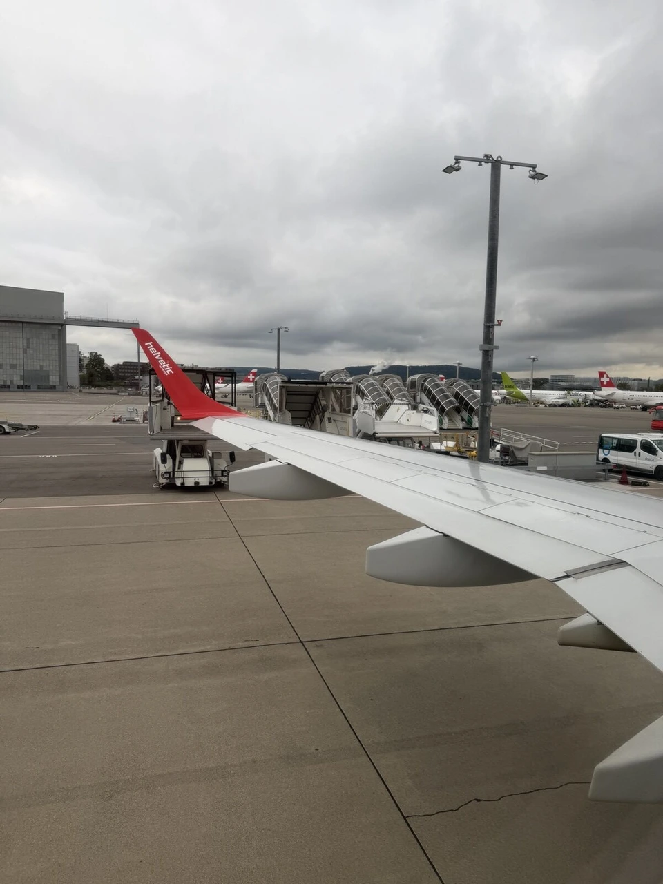 DE4310の窓から見たチューリッヒ空港の駐機場と、赤いウイングレットの主翼