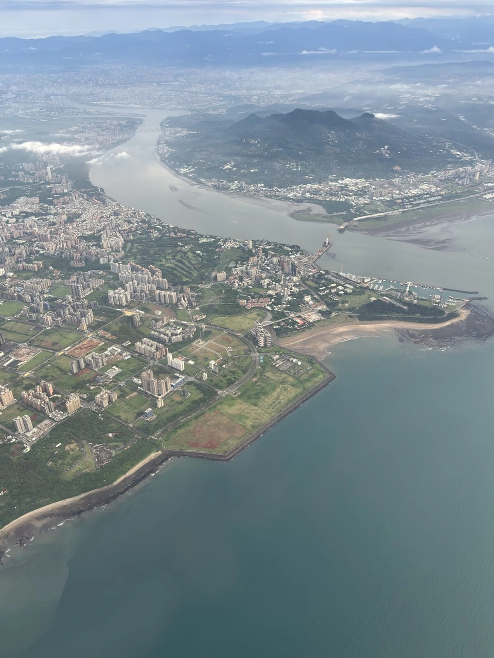離陸後に見た淡水河の河口と海沿いの街