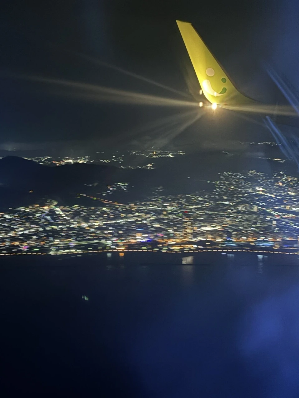 ソラシドエアのウイングレットの向こうに見える神戸の海沿いの夜景