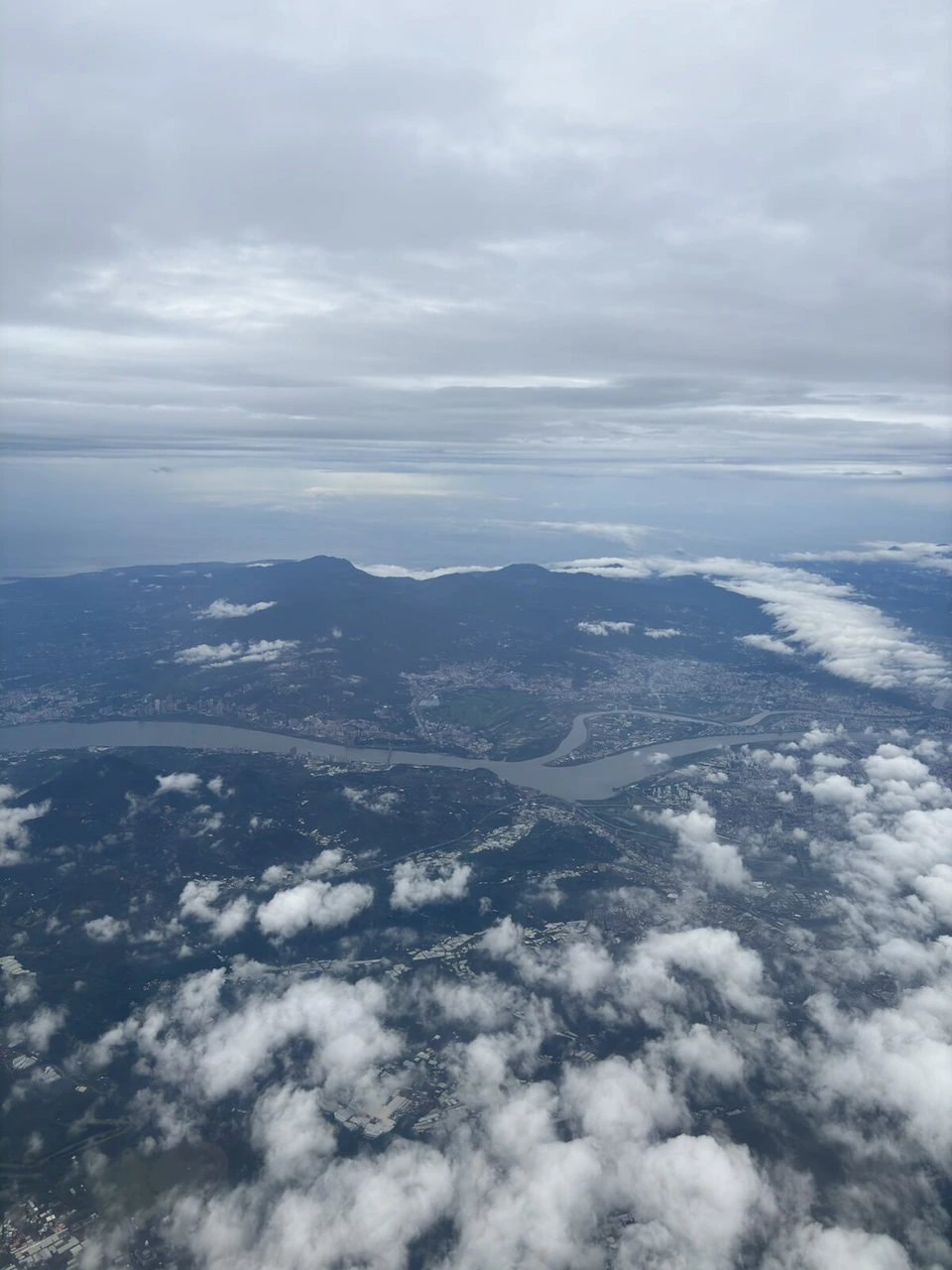 雲の下に見える台北近郊の川と山