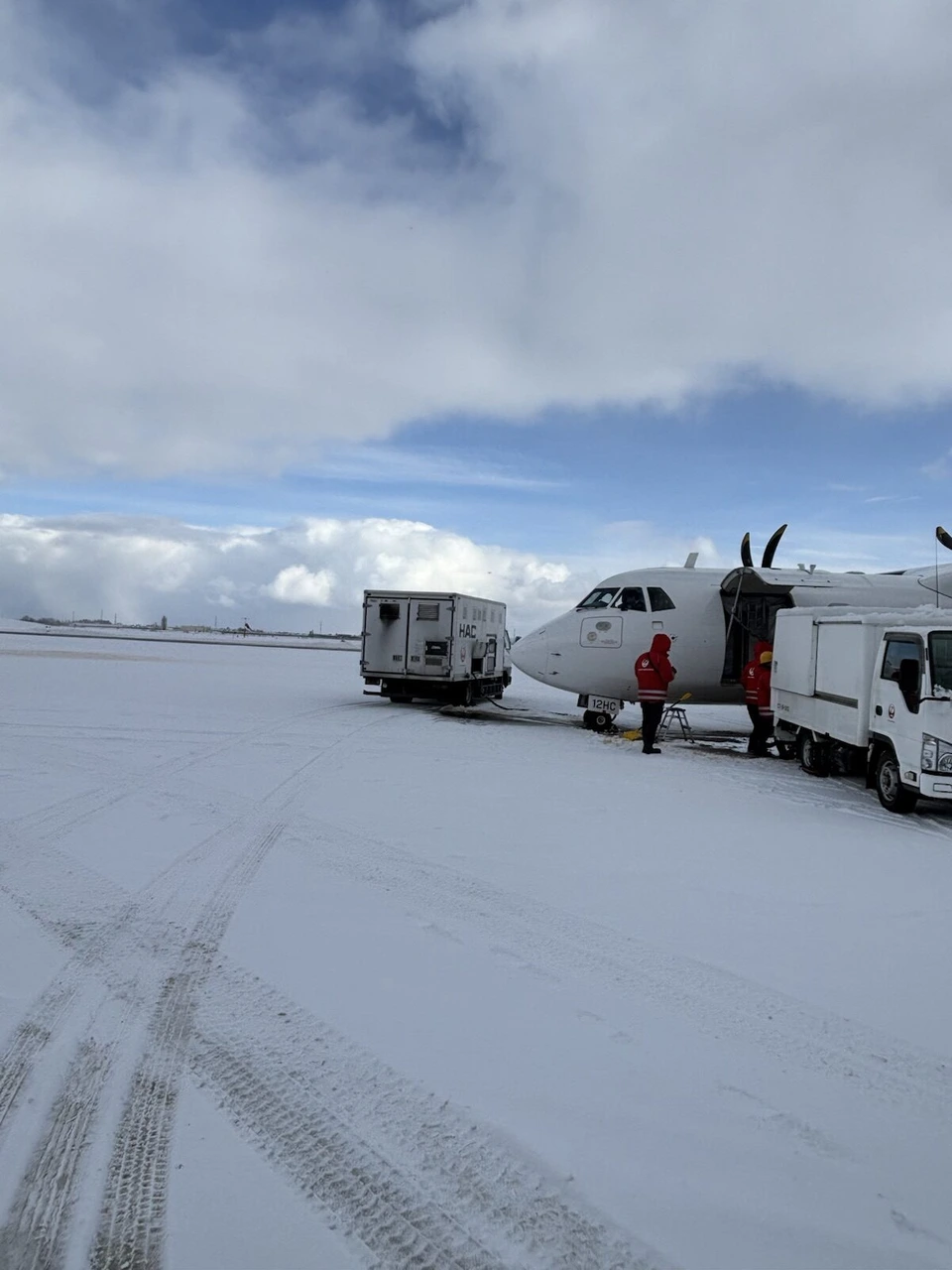 雪の丘珠空港の駐機場。作業車とATR42-600