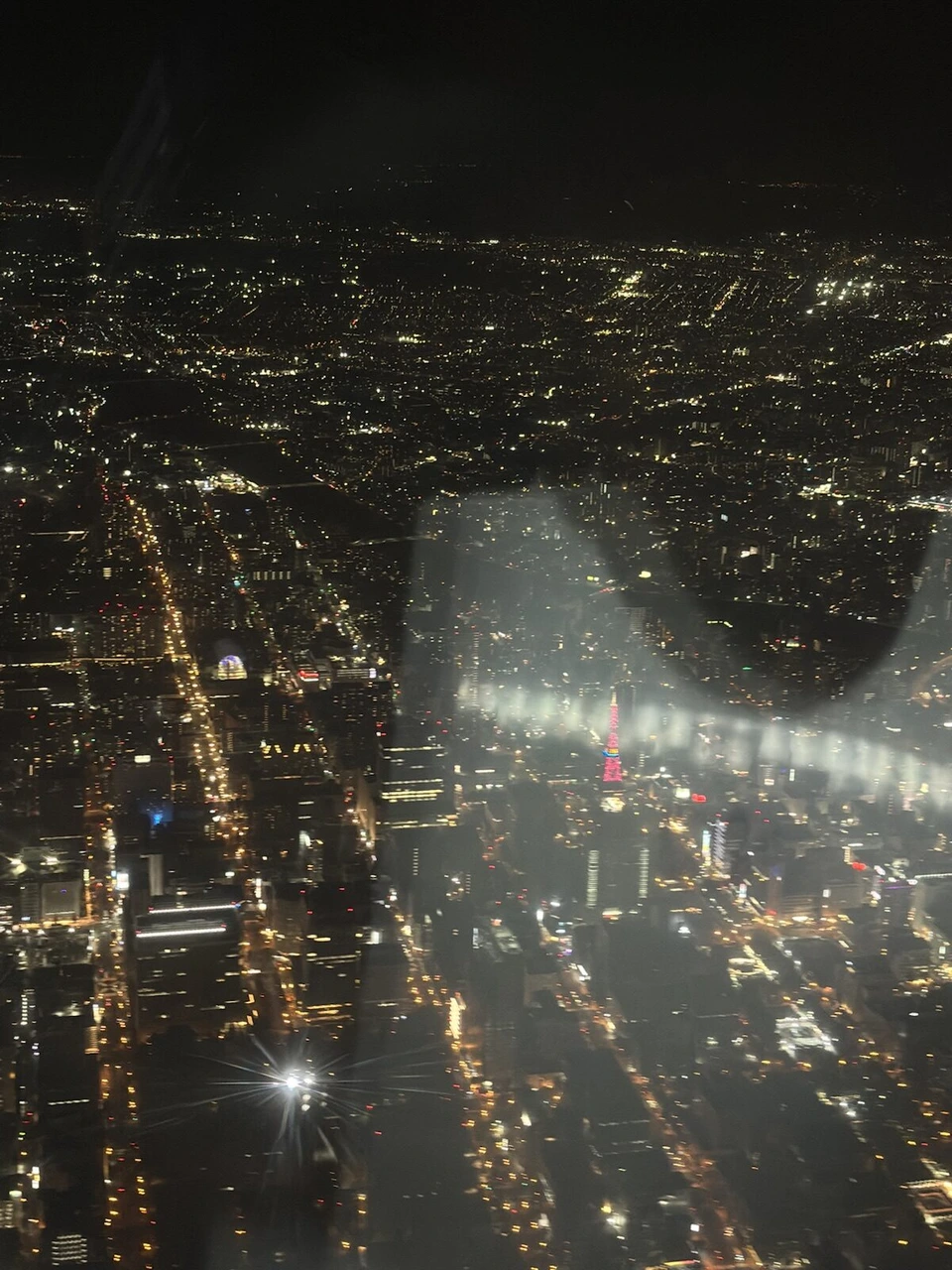 丘珠空港に着陸する前のJL2754の機窓から見た札幌の夜景。まっすぐ延びる道路の明かり