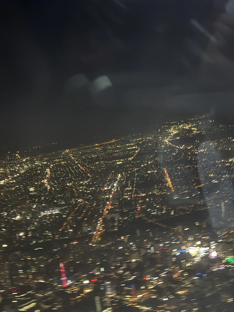 機窓から見た、地平線まで広がる札幌の街の明かり