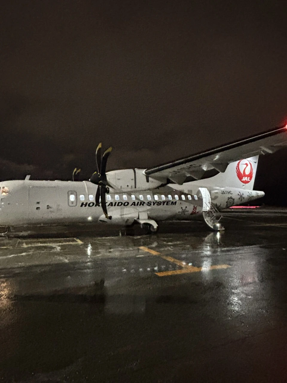 夜の丘珠空港の駐機場に止まる、女満別行きJL2727のHACのATR42-600(JA11HC)