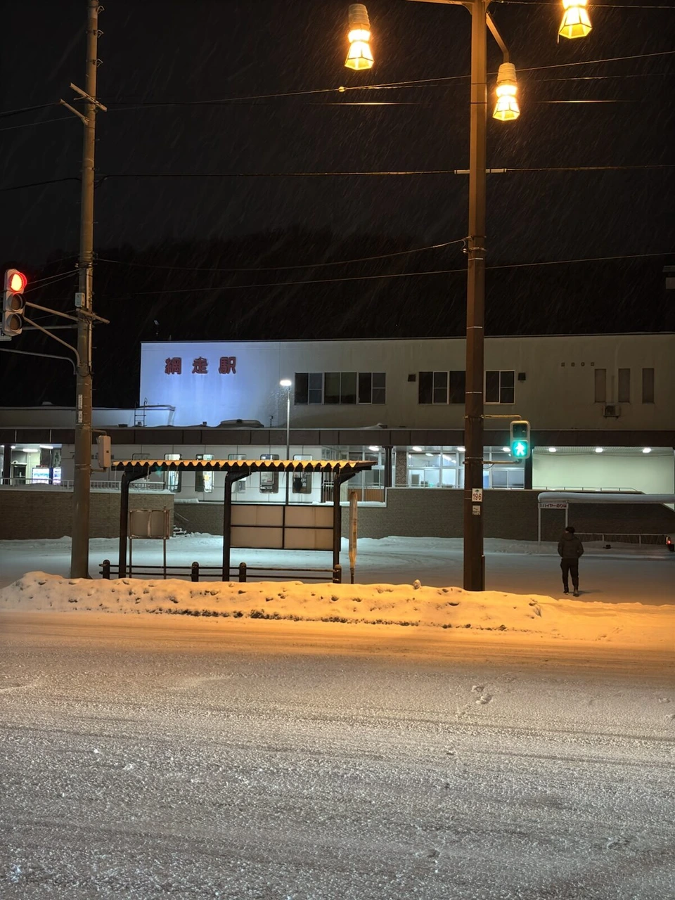 夜の網走駅前。街灯と雪の積もった駅前広場