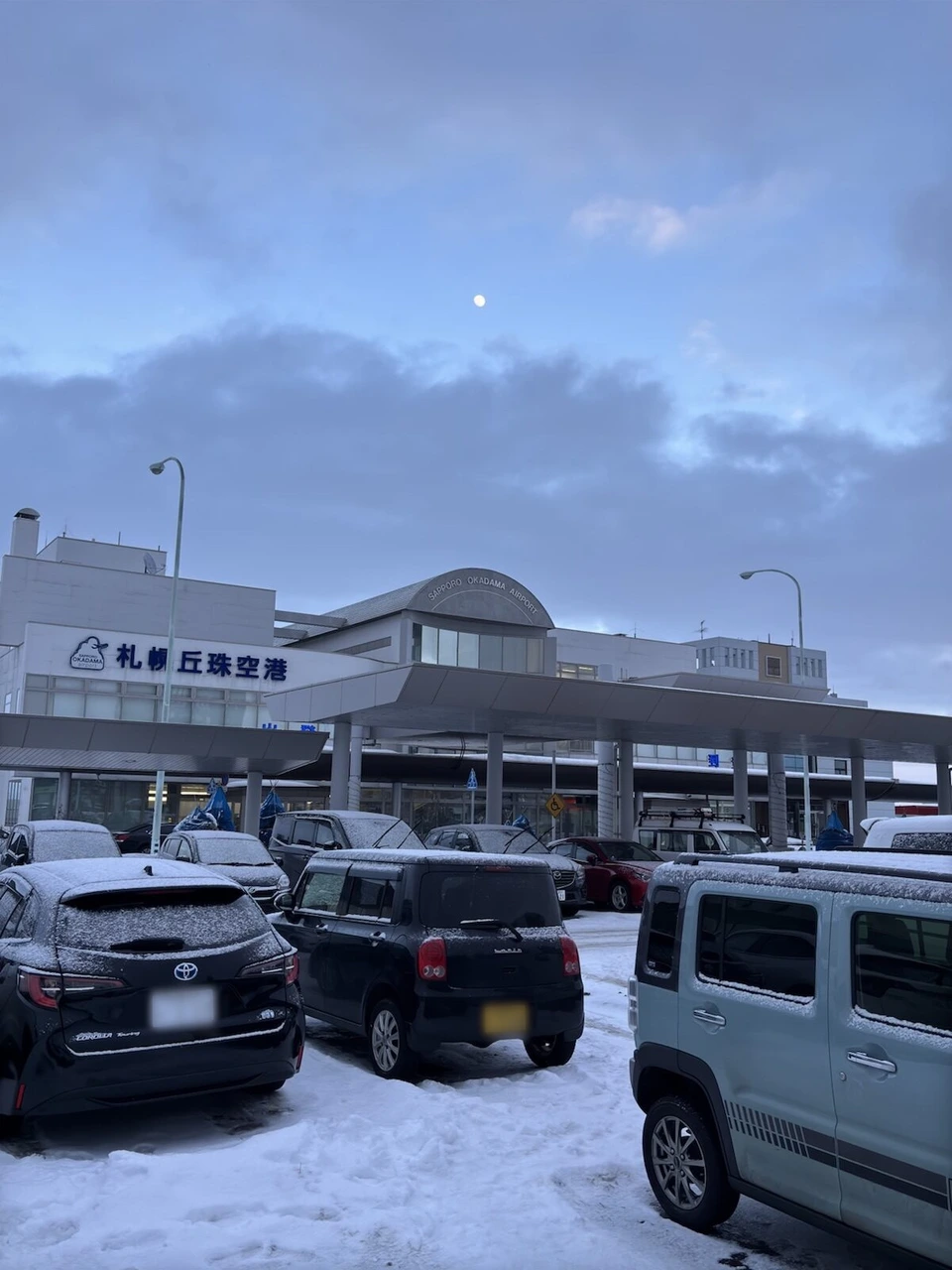駐車場の車越しに見た札幌丘珠空港のターミナルビル