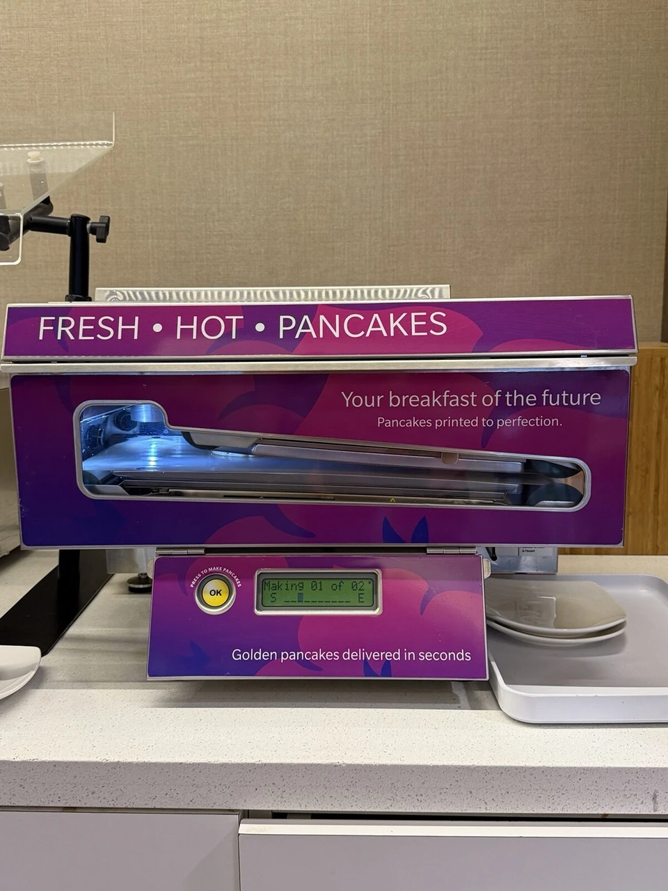ホノルル空港のラウンジにあるパンケーキの自動焼き機。FRESH HOT PANCAKESの表示