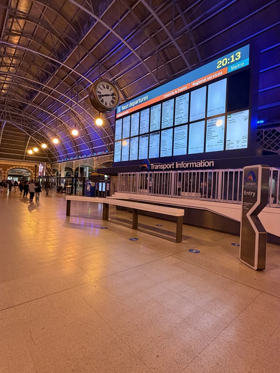 夜のシドニー・セントラル駅のコンコース。発車案内板と大きな時計