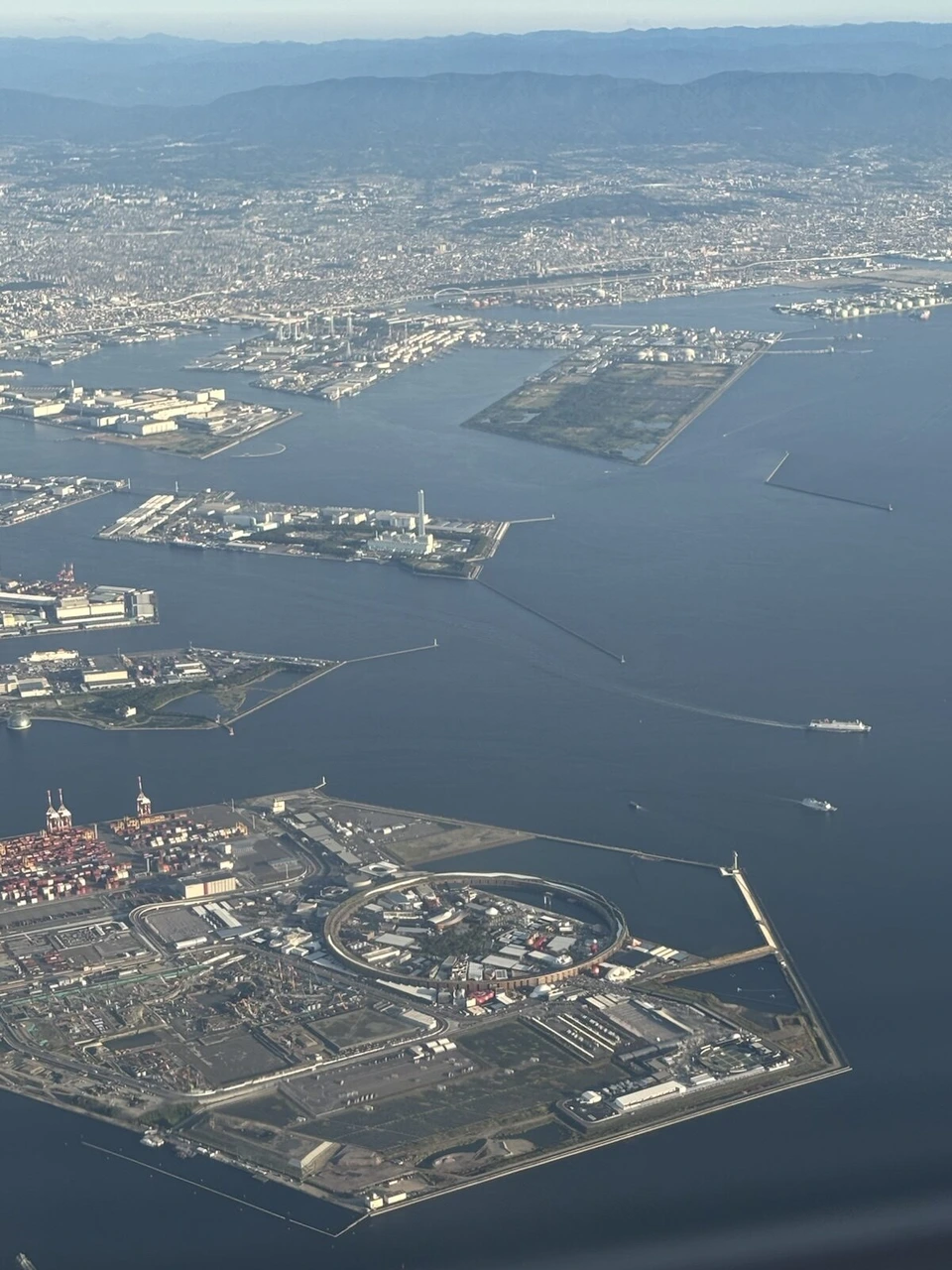 伊丹→長崎JL2377の機窓から見た大阪湾の人工島。手前の島に万博会場の大屋根リング