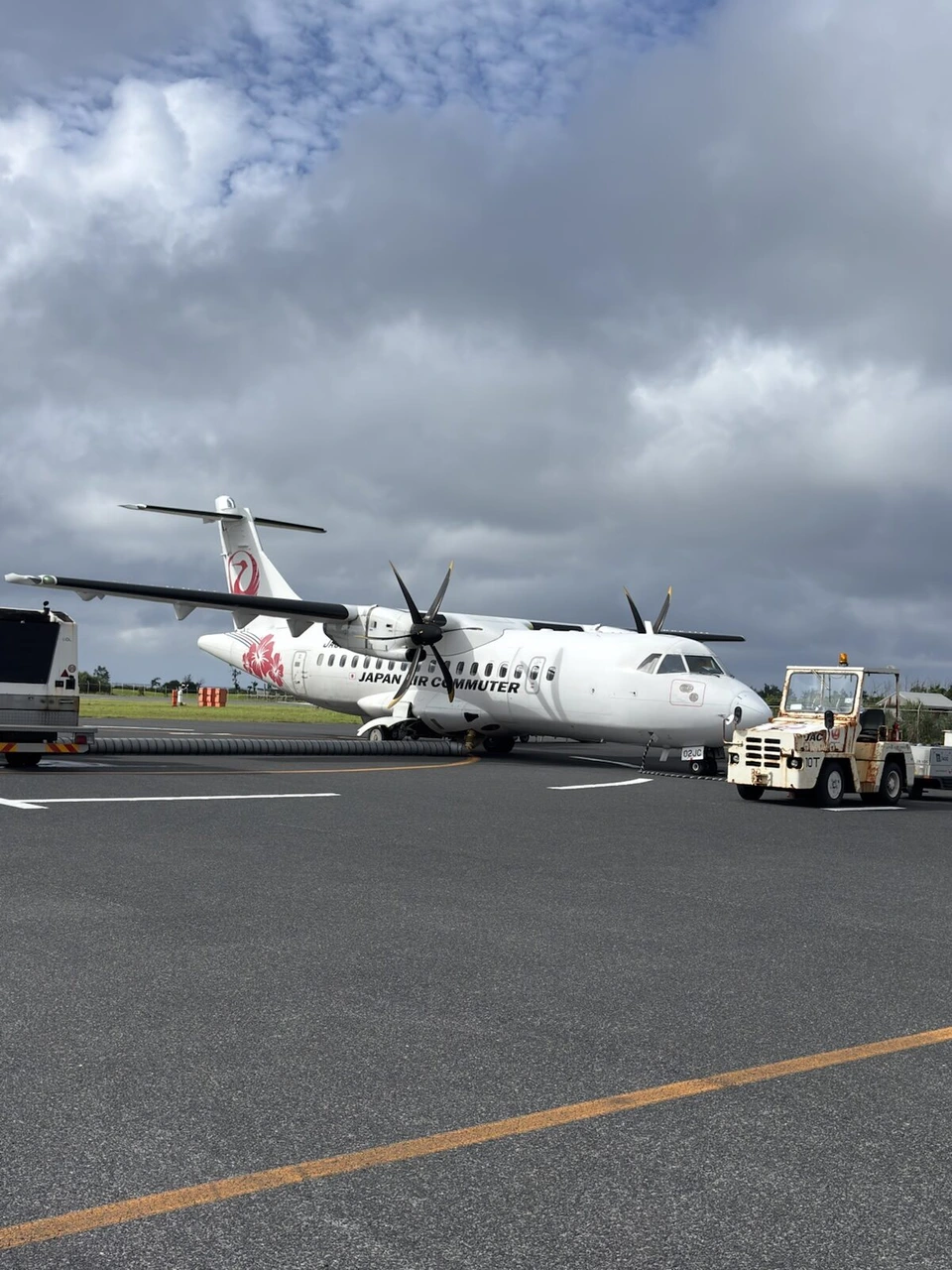 喜界空港の駐機場に止まる、尾翼に花の絵が描かれたJACのATR42-600