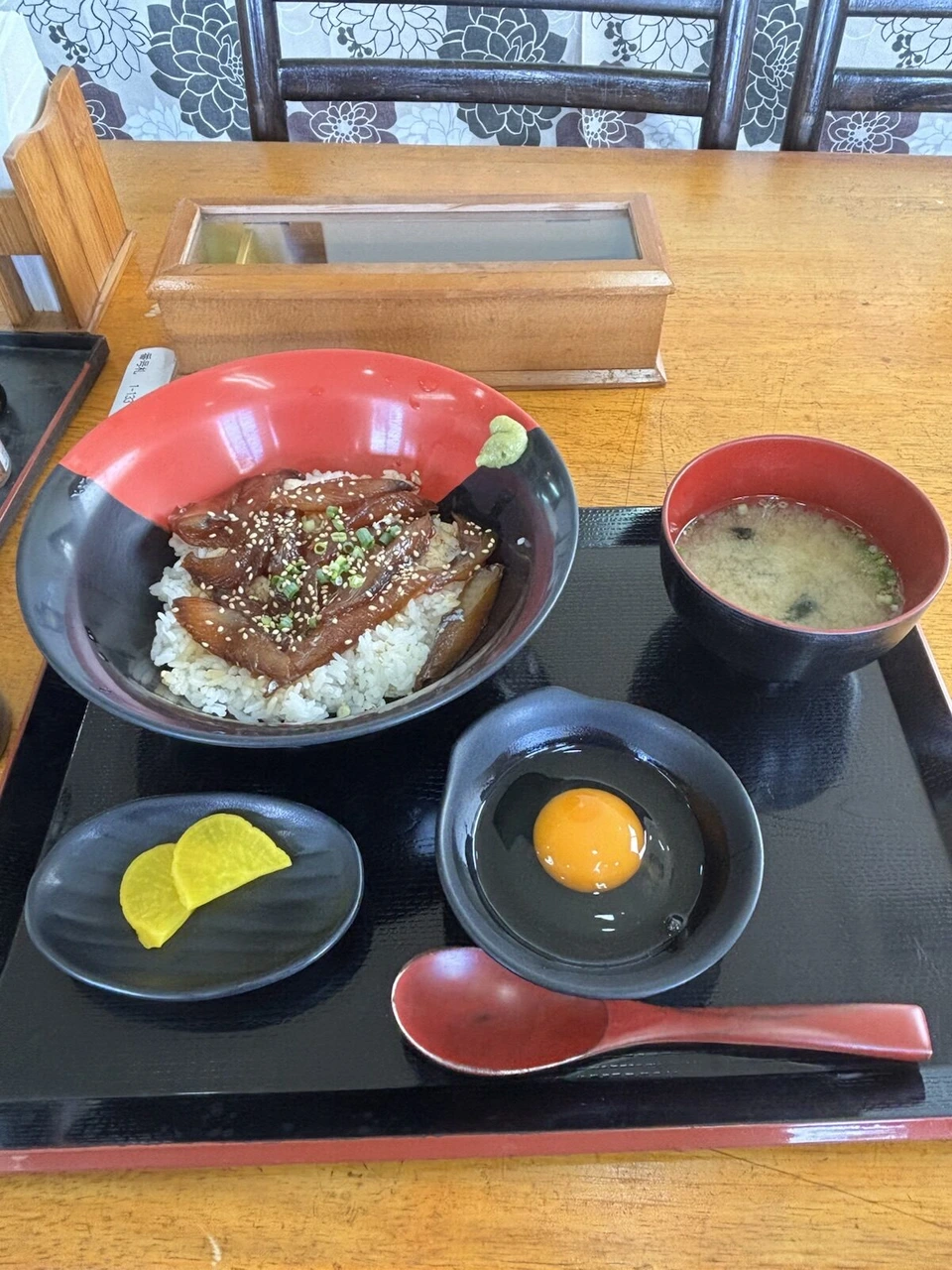 屋久島空港の食堂で食べた、甘辛いタレの魚がのった丼と生卵、みそ汁、たくあんのセット