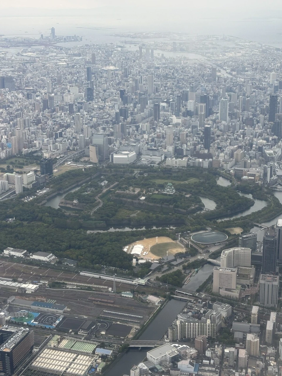 JACのATR42-600の機窓から見下ろした大阪城公園と天守閣、周りのビル群