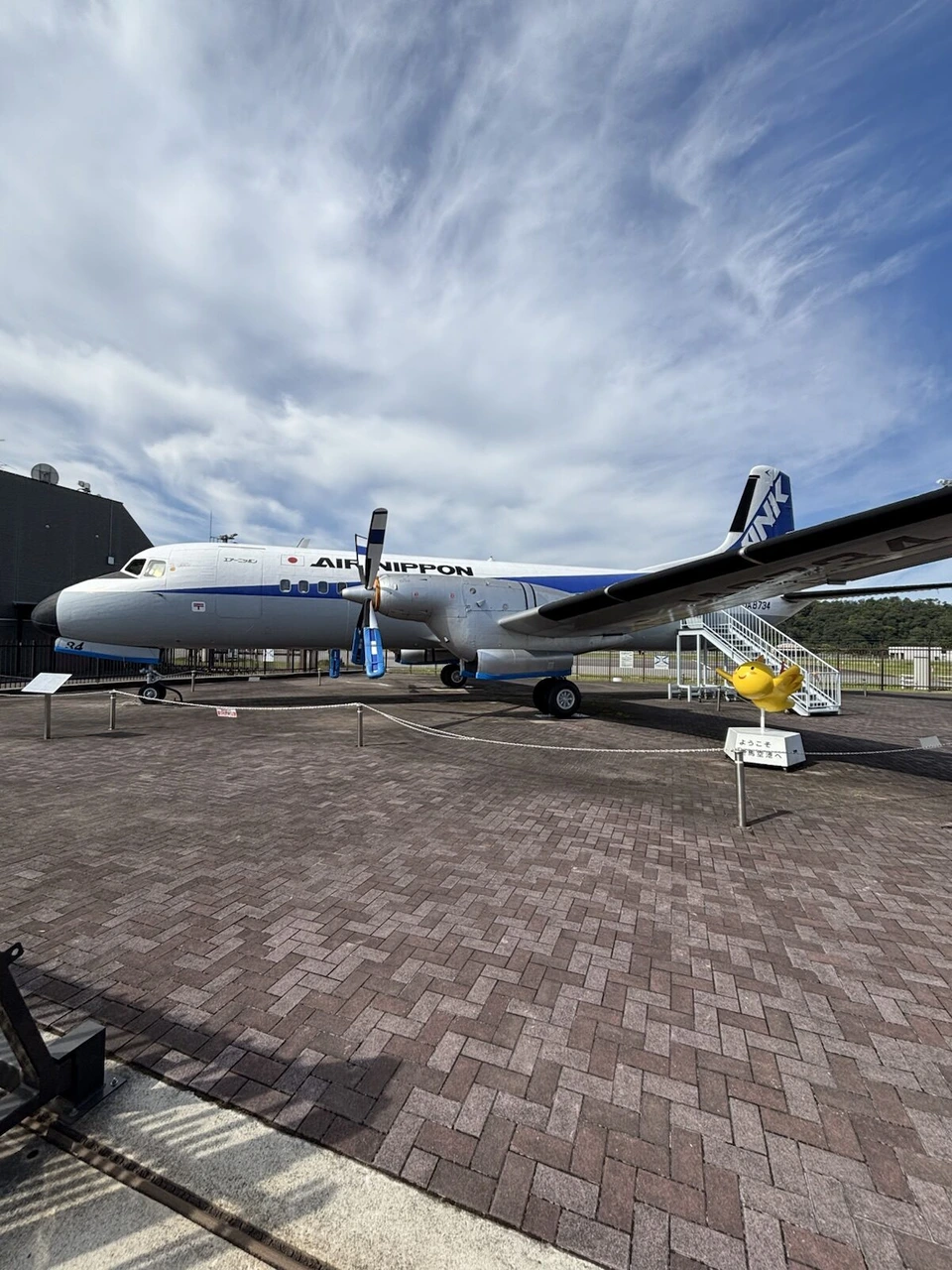 但馬空港の屋外に展示されたエアーニッポンのYS-11と、横に置かれた鳥のオブジェ