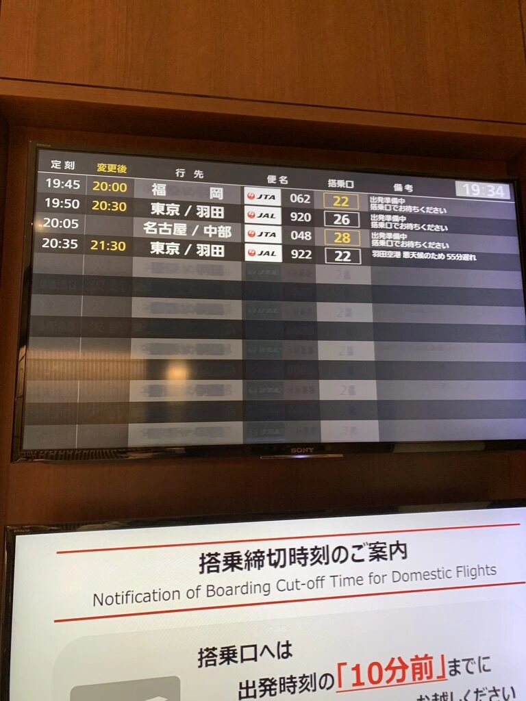 那覇空港の出発案内表示。JL920東京羽田行きの出発時刻の変更、搭乗口26。下に搭乗締切時刻の案内