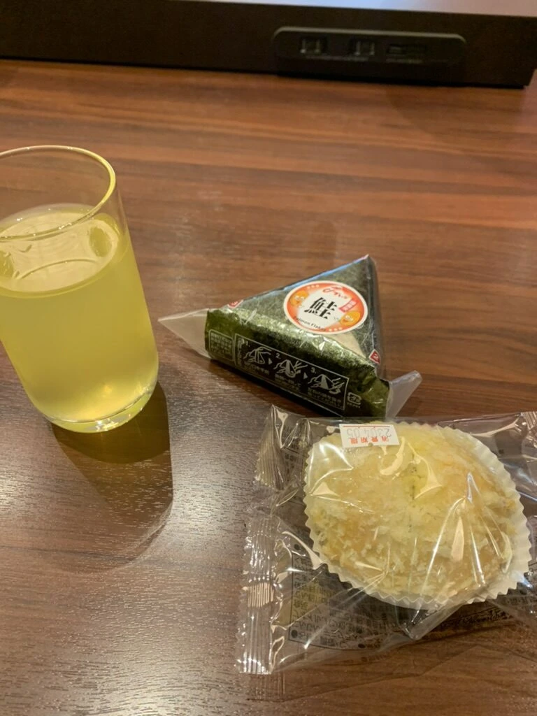 那覇空港のJALラウンジでもらったおにぎりとマフィン、グラスのお茶