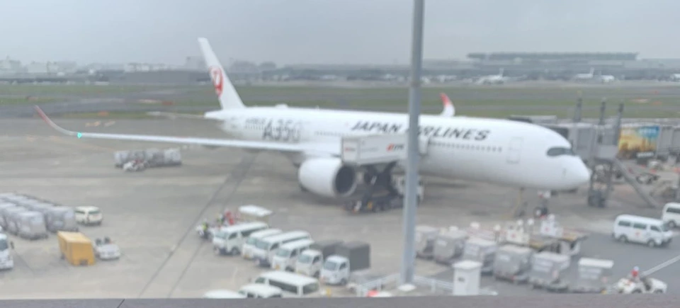 空港のラウンジの窓越しに見た、搭乗橋につながったJALのエアバスA350