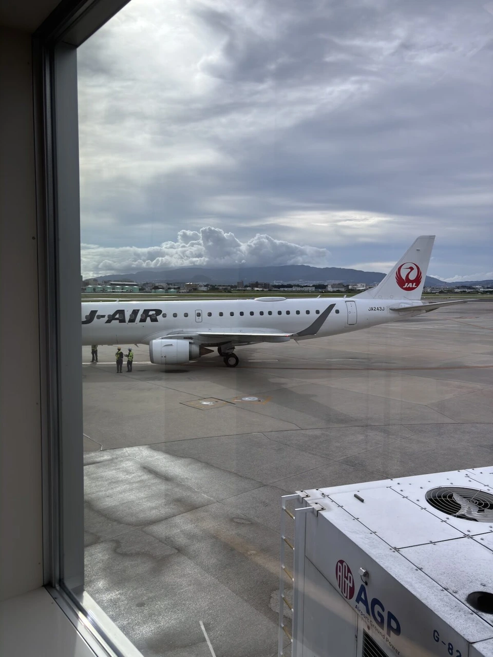 伊丹空港16番搭乗口からガラス越しに見た、三沢行きJL2163のJ-AIRのE190(JA243J)