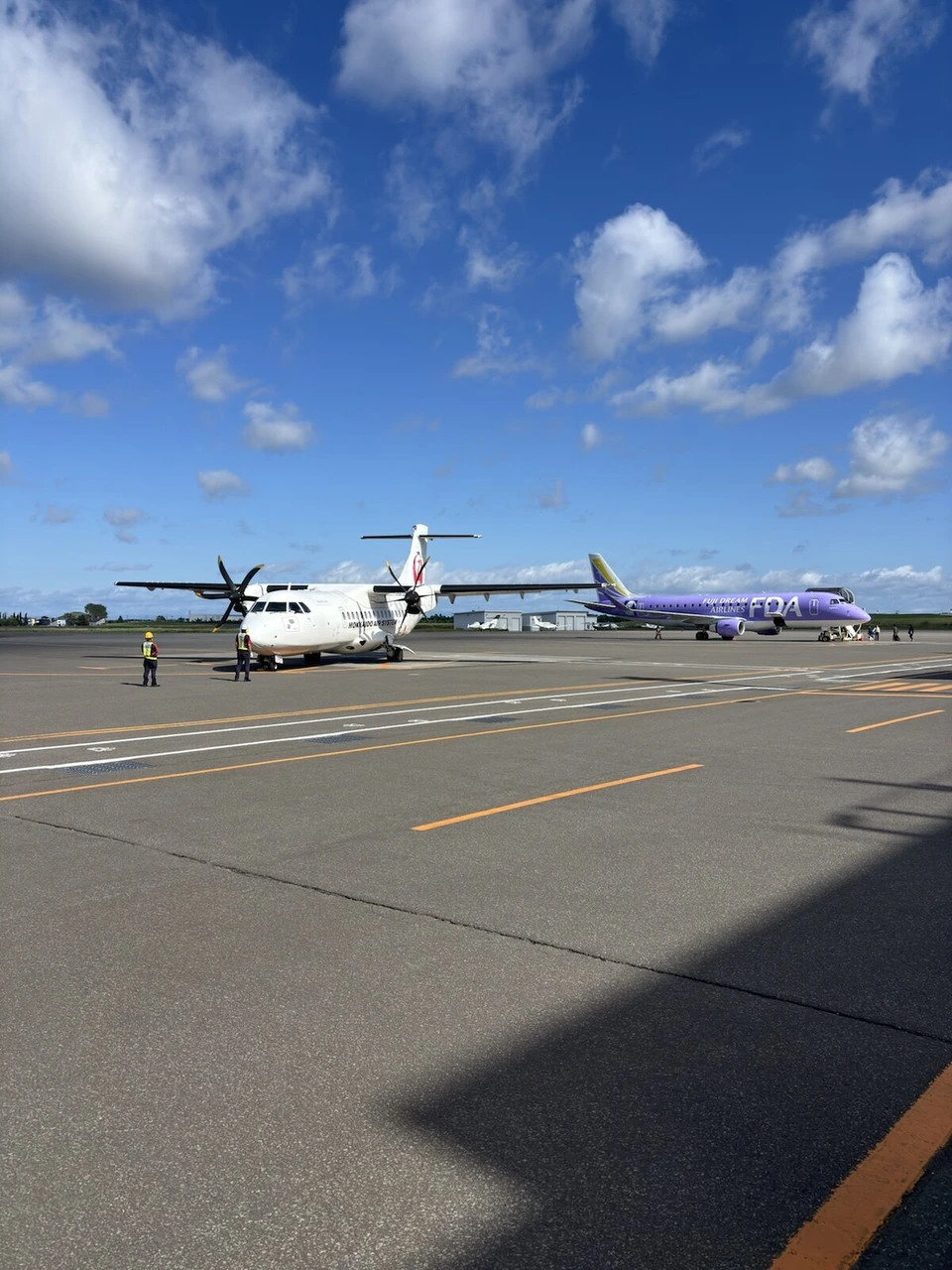 晴れた丘珠空港。駐機場のATR42-600(JA04JC)と紫色のFDAのエンブラエル機